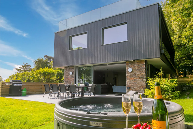 View of Sparrow's Nest from the back garden, with a hot tub in the foreground.